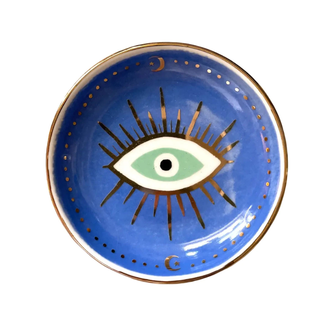 round ceramic dish with an image of an eye eye in the center with gold metallic detailing.