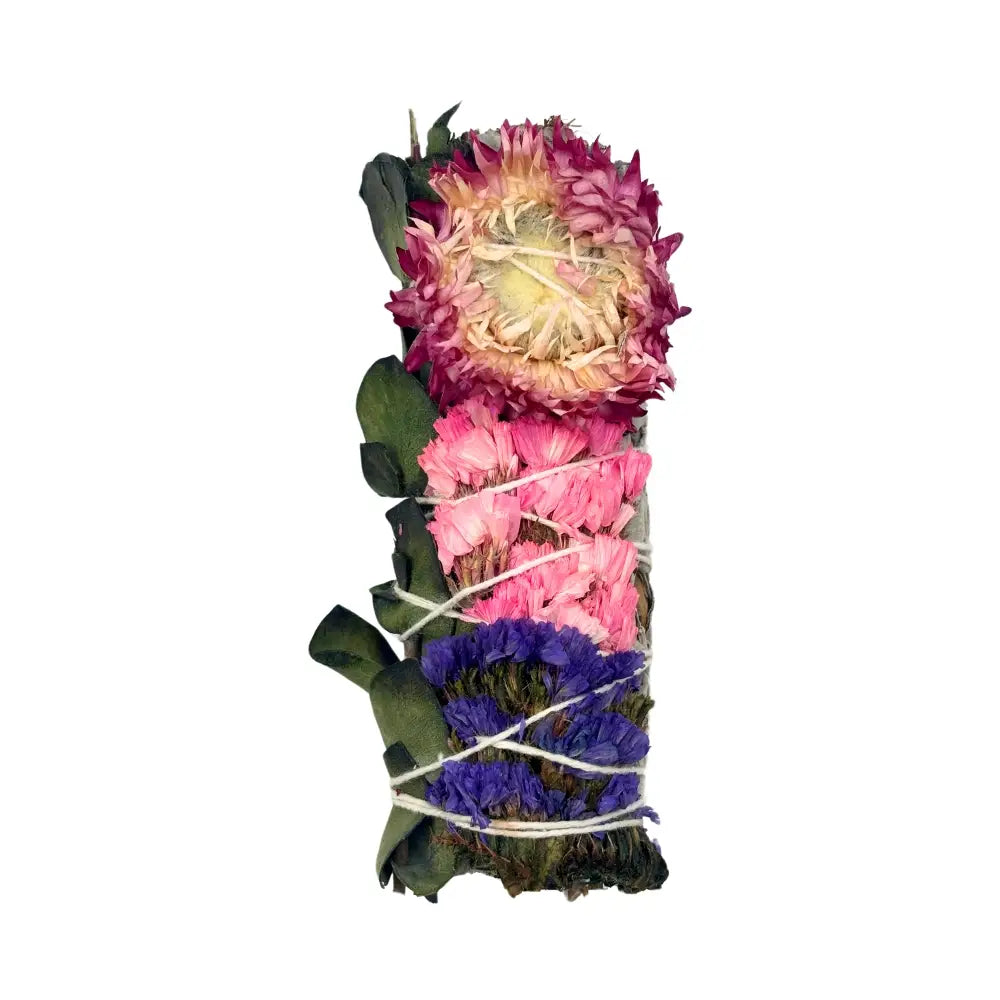 Hand-tied sage bundle wrapped with white string, decorated with bands of purple flowers and hot pink strawflower, shown on a white background.