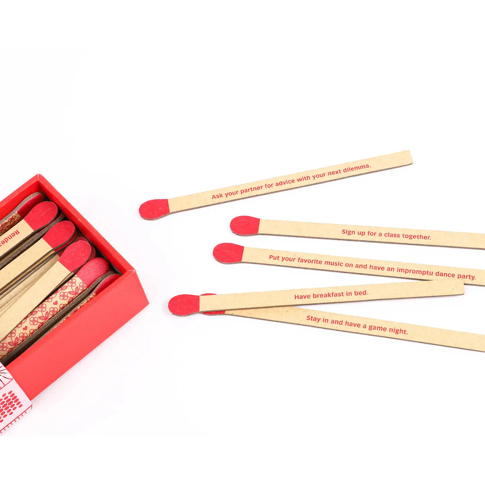 Box of romance-themed prompt sticks with individual sticks displaying written activities for couples.