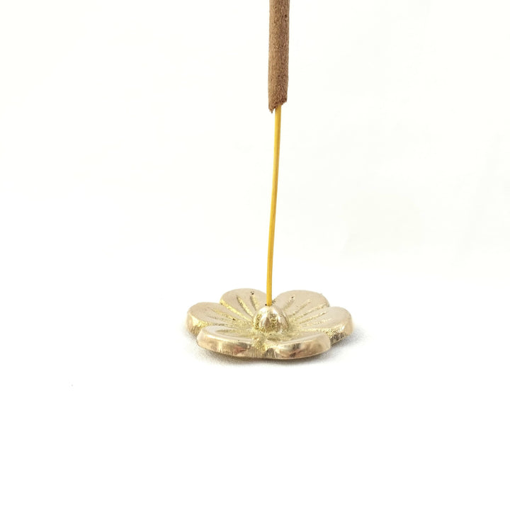 Brass flower incense stick holder with an incense stick