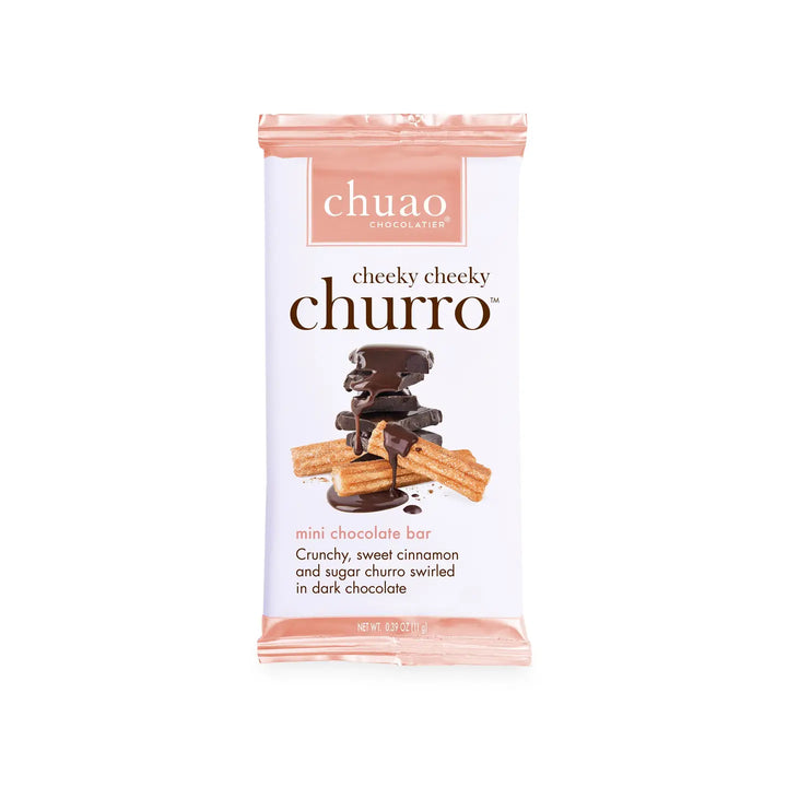 A .39 oz Chuao Chocolatier Cheeky Cheeky Churro chocolate bar featuring a packaging design with stacked dark chocolate pieces drizzled in chocolate and paired with churros dusted in cinnamon and sugar. The label highlights "crafted with joy" and fair trade certified ingredients.