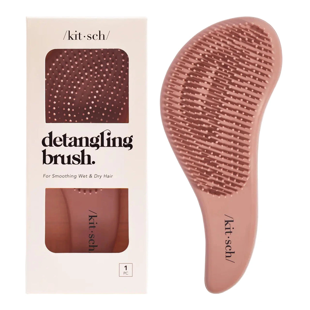 Terracotta-colored detangling brush shown with its packaging, featuring flexible bristles and a curved handle.