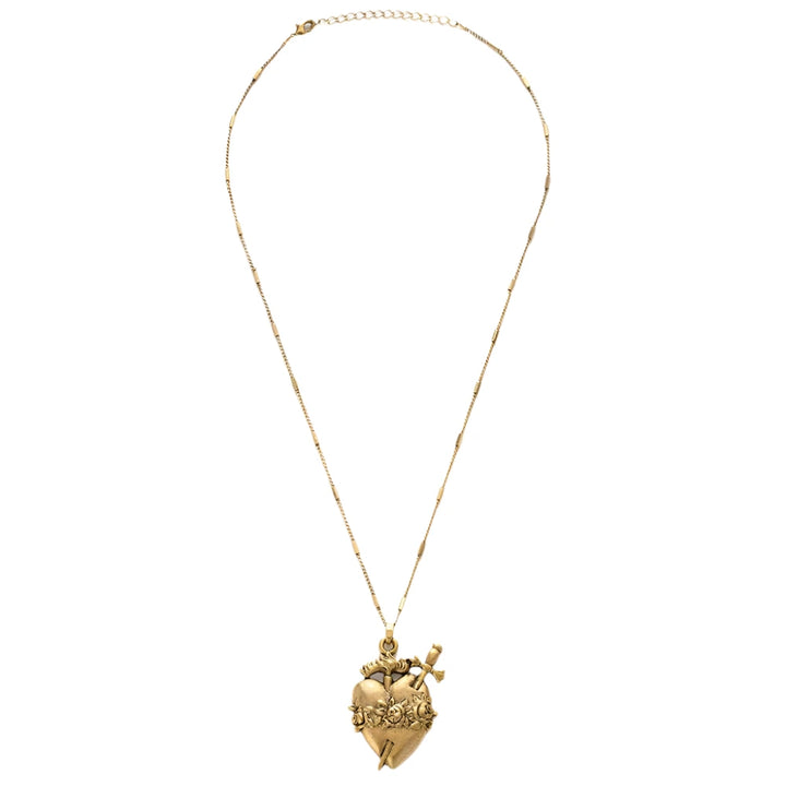 A gold-tone Immaculate Heart Necklace featuring an ornate sacred heart pendant with detailed roses, a flame, and a piercing dagger. The pendant hangs from a delicate gold chain against a white background.