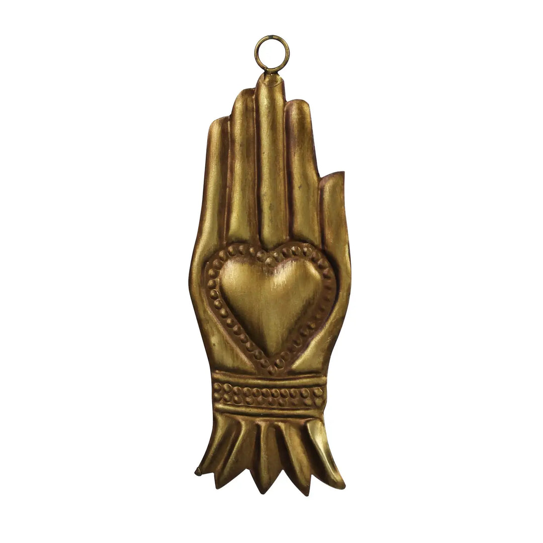 Gold-tone metal milagro in the shape of an upright hand with a raised heart in the palm and a small hanging loop at the top.