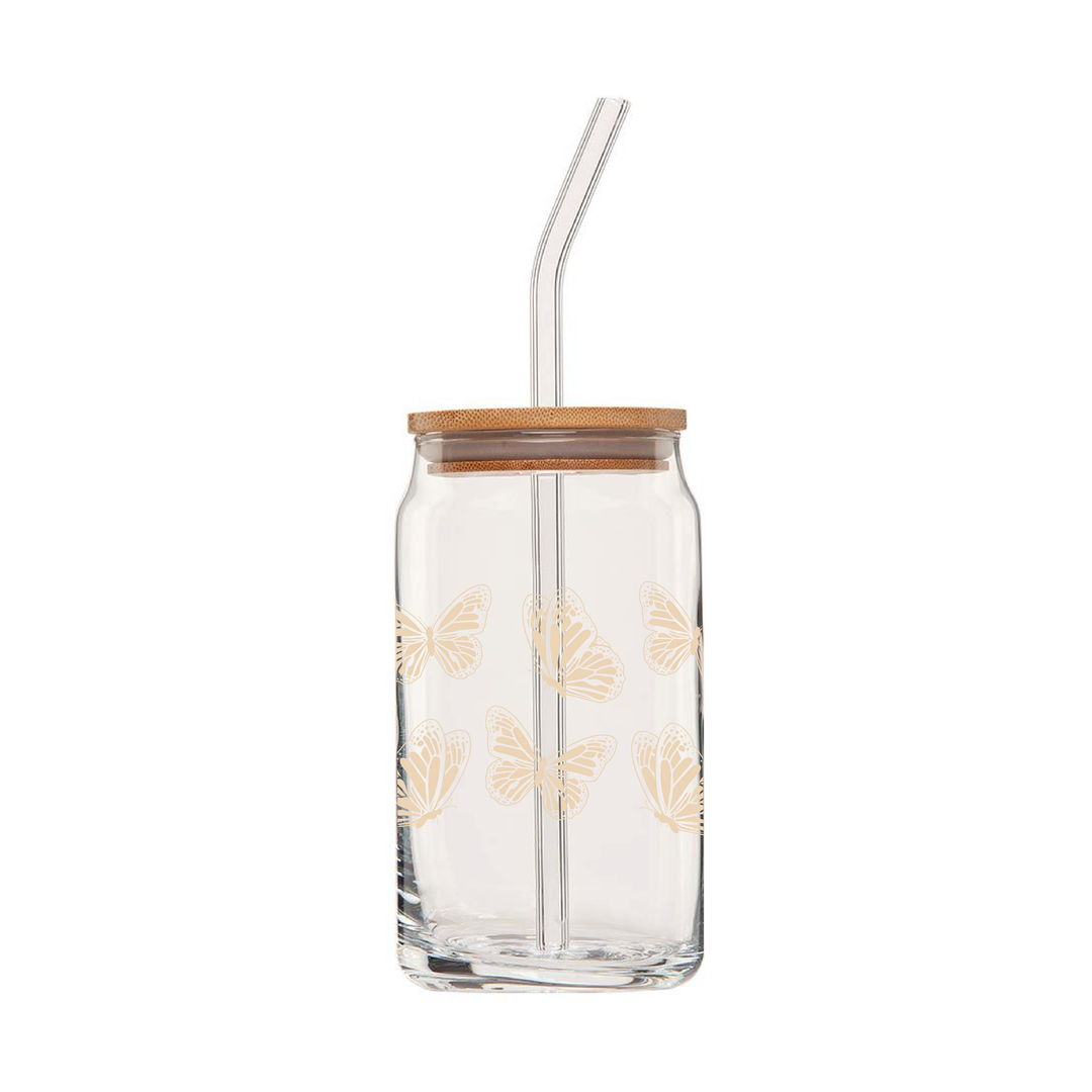 Clear can glass features a wrap around design of ivory colored monarch butterflies. Pictured with bamboo lid & glass straw