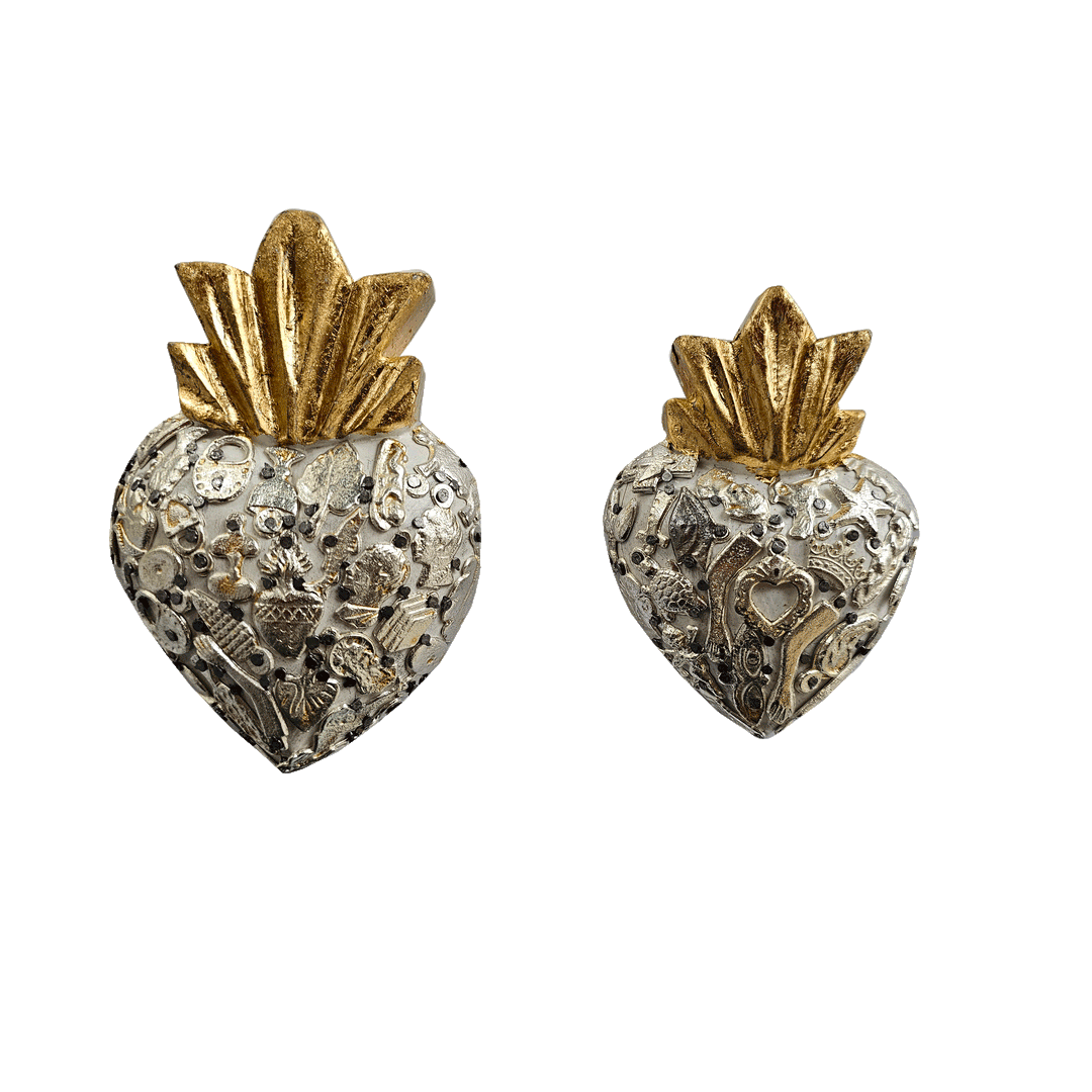 a set of white milagro hearts, one larger than the other,  with various styles of milagro charms