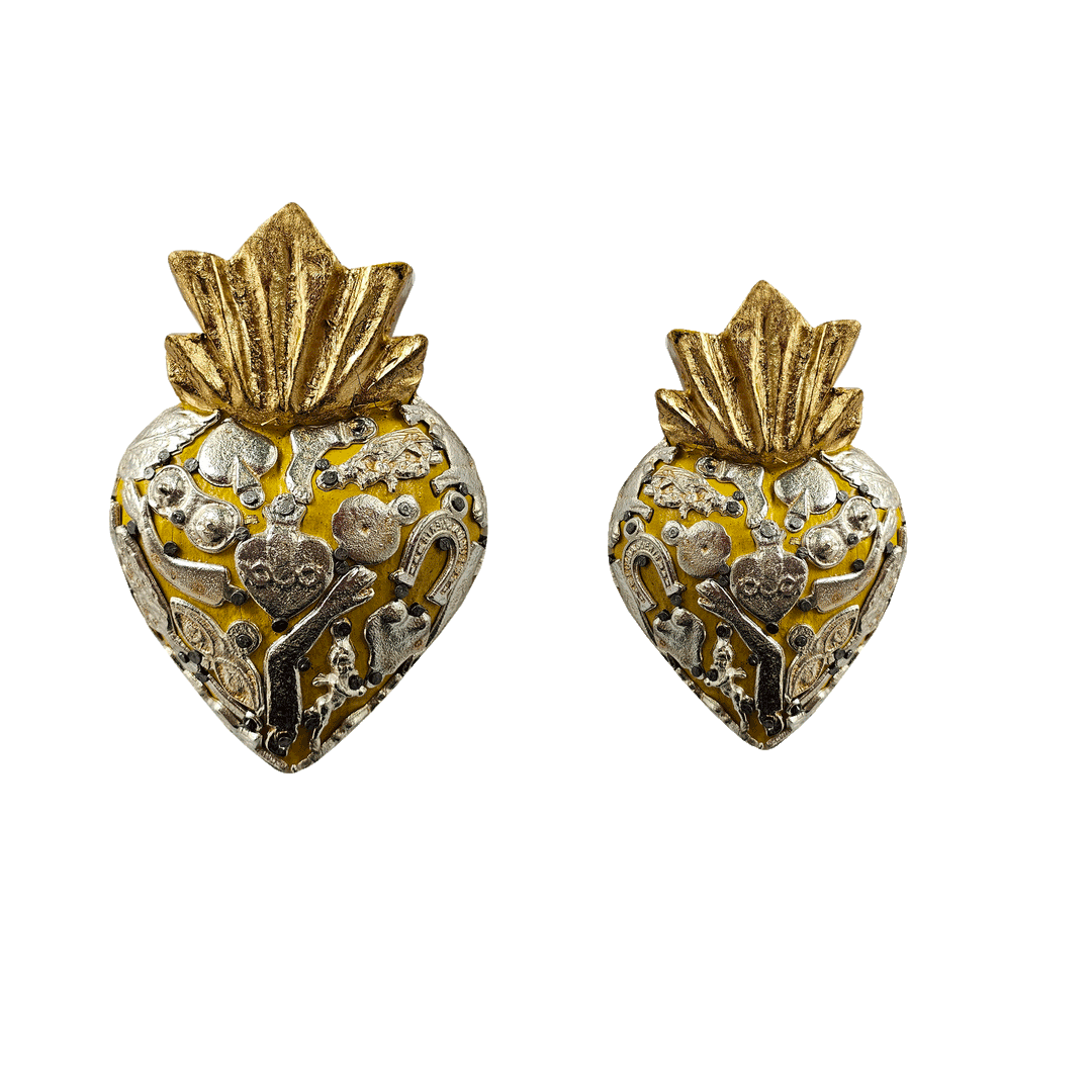 a set of yellow milagro hearts, one larger than the other,  with various styles of milagro charms