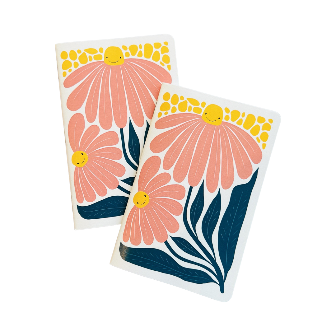 two sets of white journals with illustrations of two pink daisies with smiley faces
