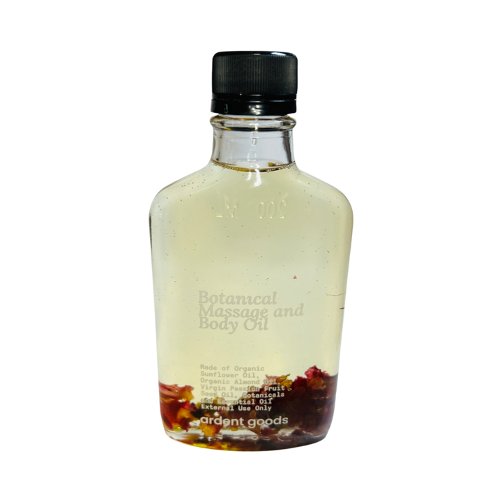 clear bottle with oil infused with dried flowers. Brand: Ardent Goods