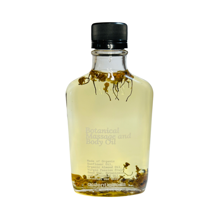 clear bottle with oil infused with dried flowers. Brand: Ardent Goods