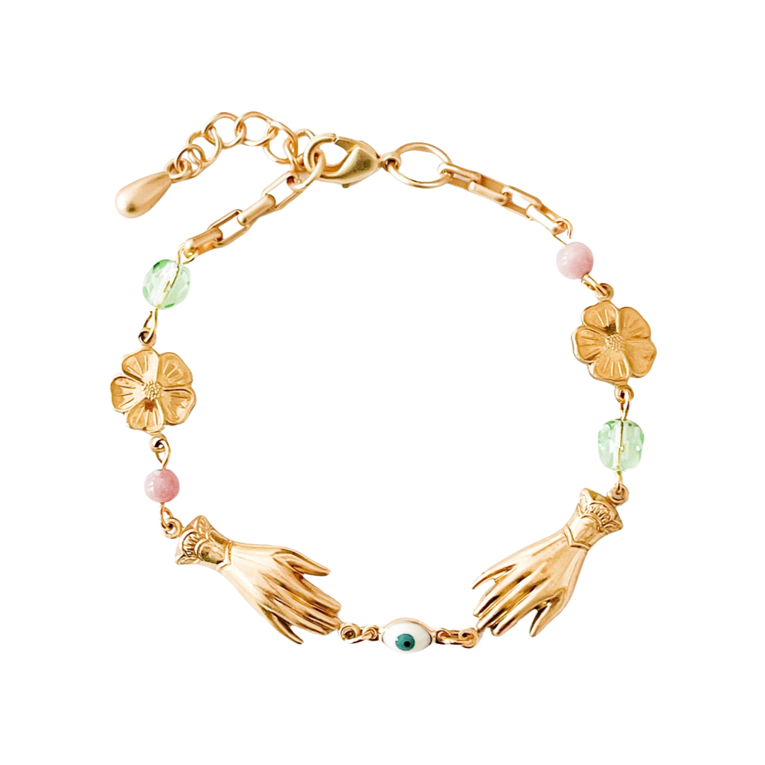 gold bracelet that features gold bird, hand and flowers charms along with multi-colored glass beads.