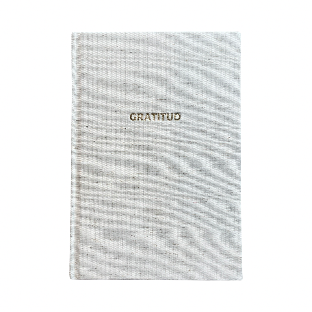 off white with grey speckles hardcover journal with the word Gratitud in gold foil lettering