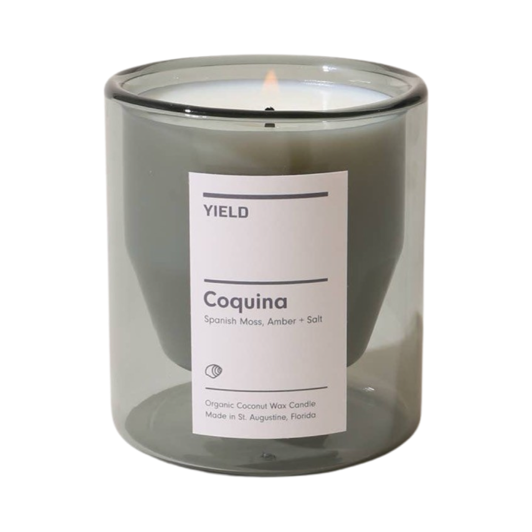 light gray double walled glass vessel candle with a white branded label
