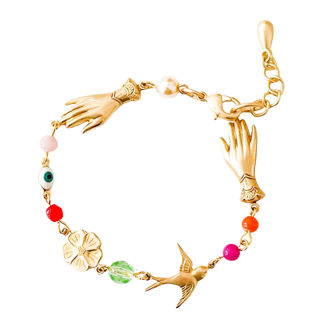 gold bracelet that features gold bird, hand and flowers charms along with multi-colored glass beads.