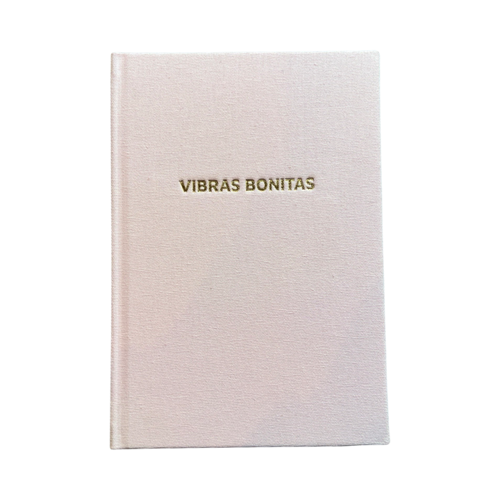 Blush colored hardcover journal with the phrase VIbras Bonitas in gold foil lettering