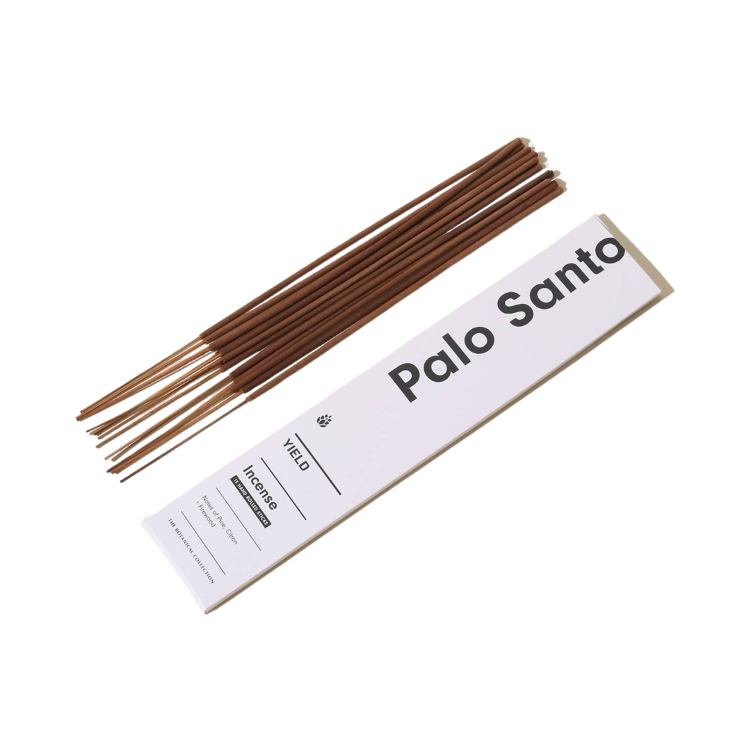 white branded box of incense with a stack of incense sticks laying to the side of it