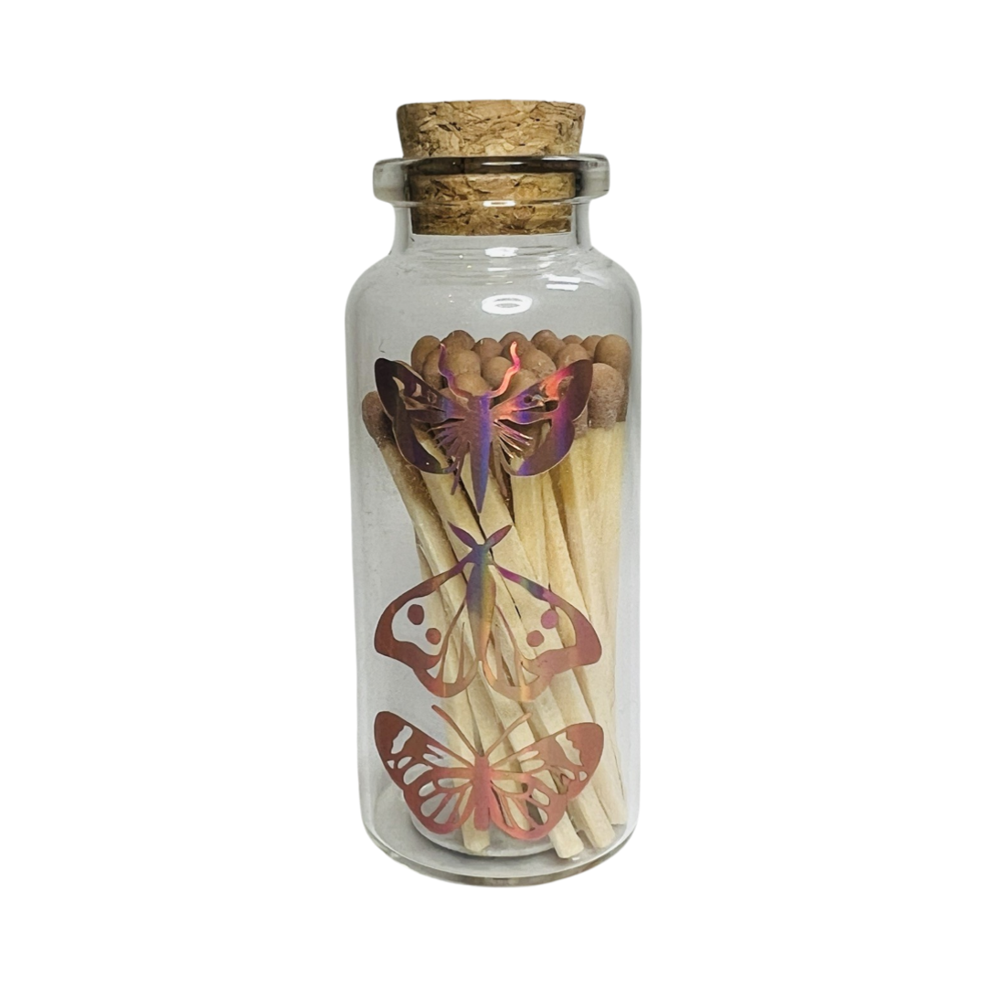 clear jar with a cork filled with matches featuring a holographic images of a trio butterflies