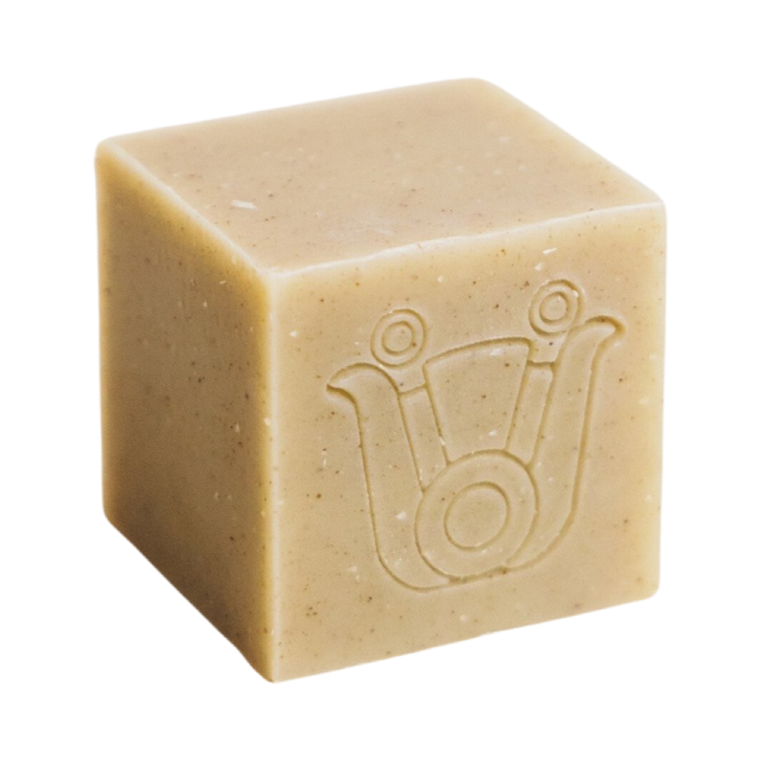 sand colored cube shaped soap with an icon design. Brand: Paca Botánica