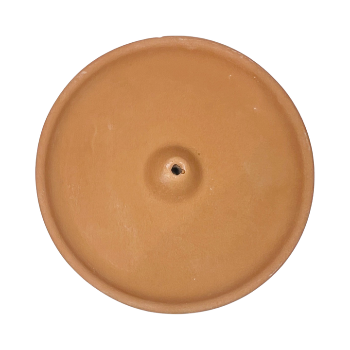 top view of a round terracotta colored incense holder