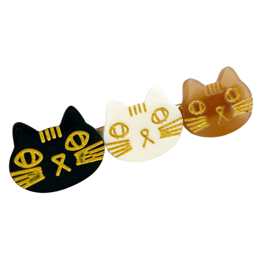 hair clip featuring faces of three cats, black , white and brown.