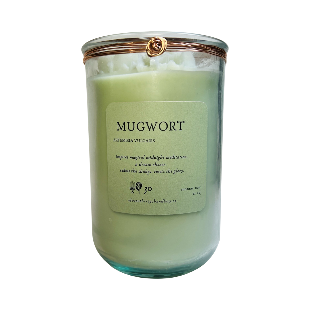 11 oz candle in a light green glass vessel with a green branded label featuring copper twist tie