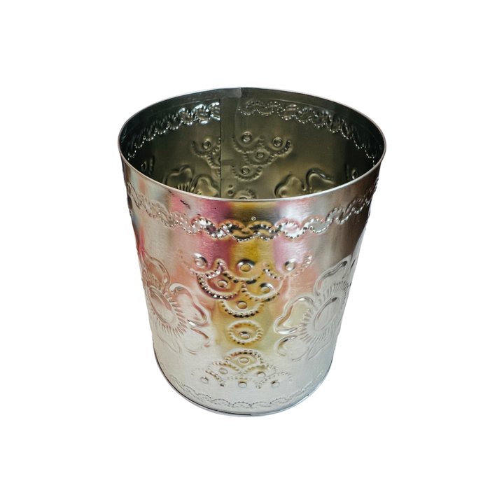 top view of a round tin canister featuring a hammered tin floral design