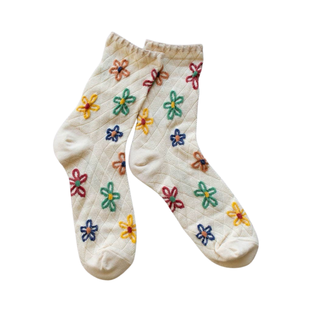 cream colored pair of socks with multi colored floral design