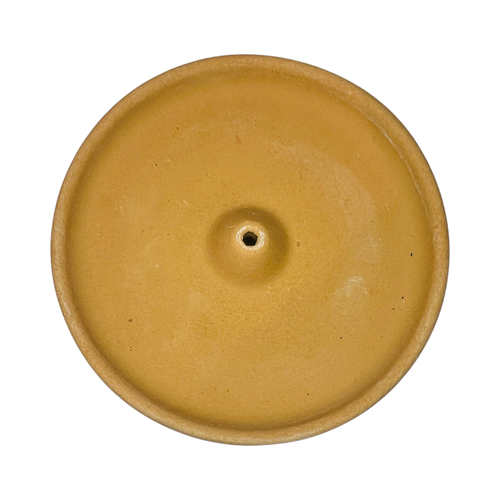 top view of a round golden sand colored incense holder