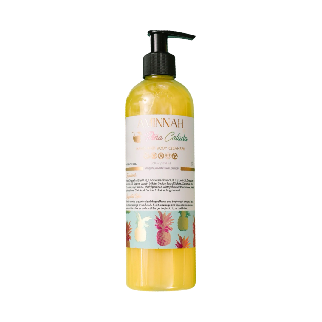 12 oz clear bottle of yellow pina colada body cleanser with a white branded label that features holographic pineapples. Brand: Aminnah