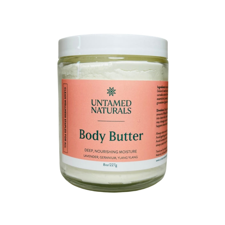 clear 8 oz jar of white body butter with a coral branded label with green lettering and a white lid. Brand: UnTamed Naturals