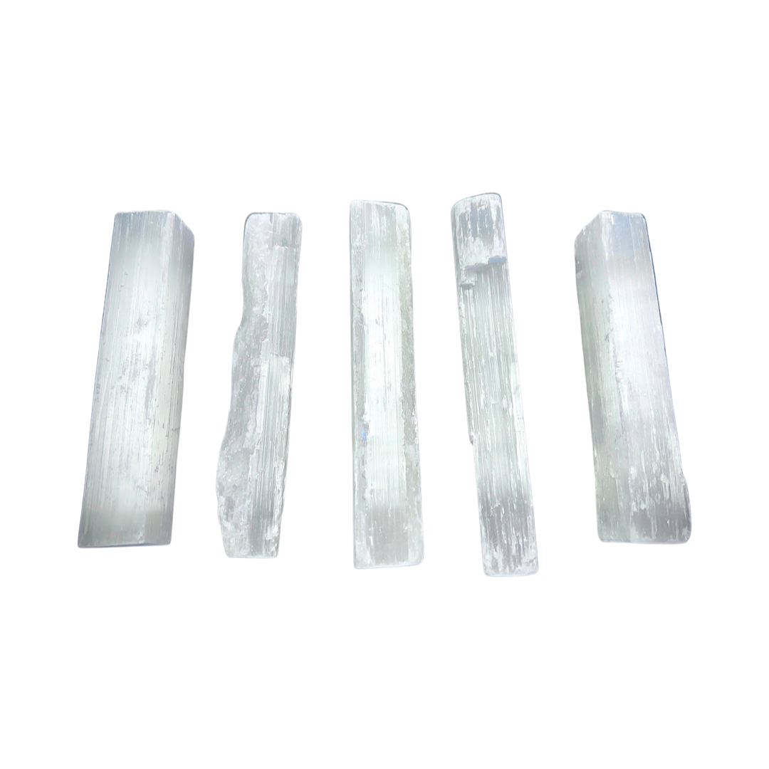 four selenite crystal wands lined up in a row