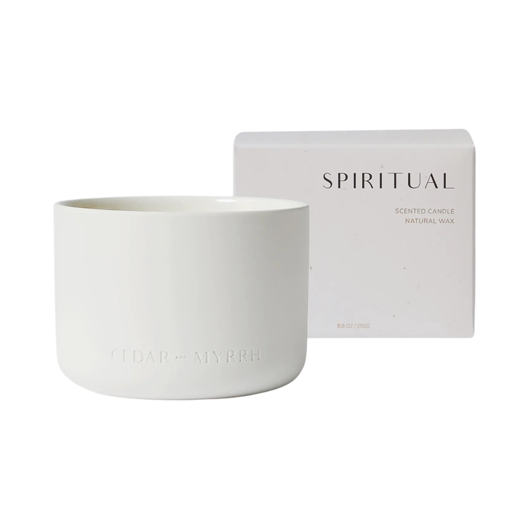 candle in a white vessel with a white box in the backgroung with the phrase Spiritual in black lettering. Brand: Cedar and Myrrh