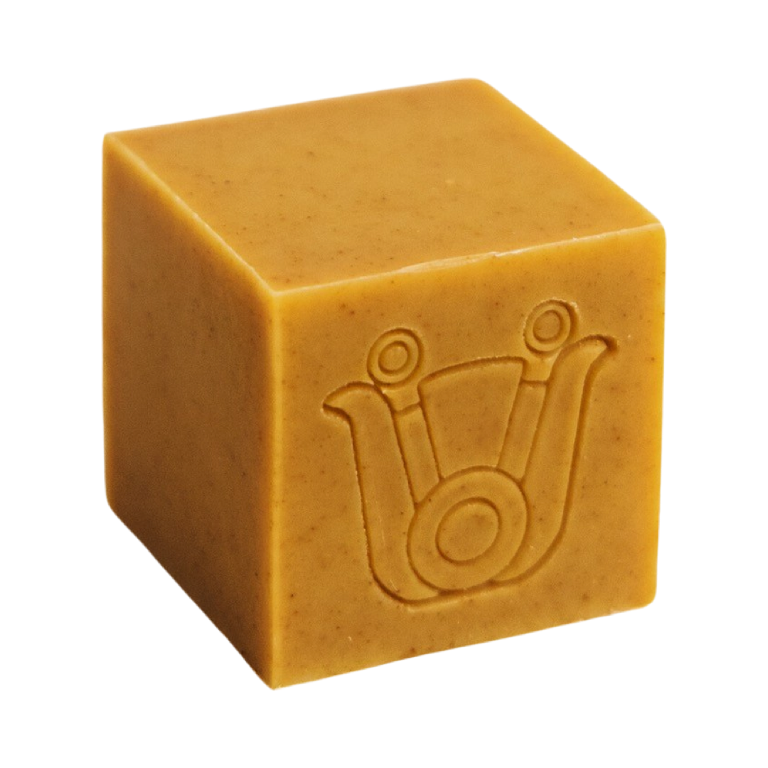 mustard colored cube shaped soap with an icon design. Brand: Paca Botánica