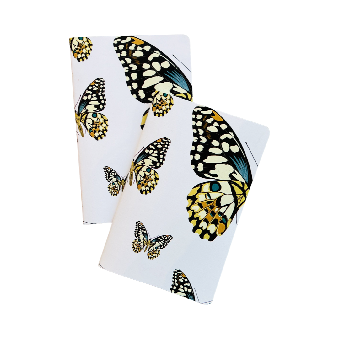 set of two white pocket journals with images of yellow,black and teal butterflies.