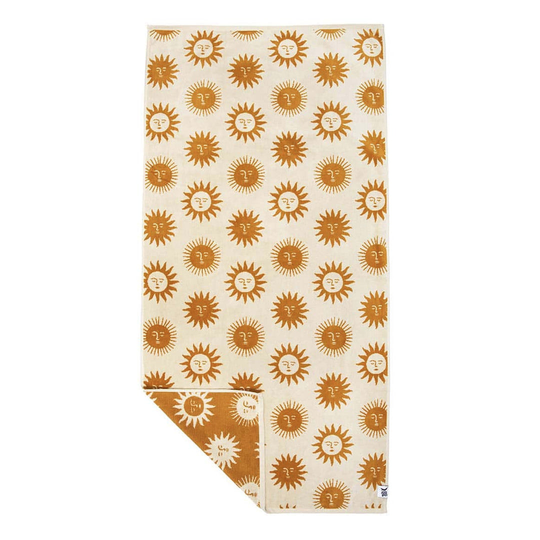beige beach towel with a sun design with one corner folded over