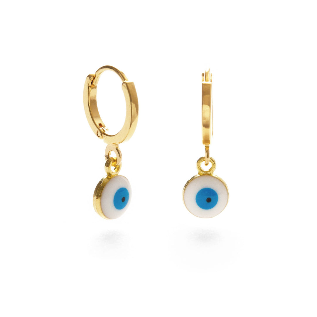 set of gold huggie earrings with a blue and white eye pendant. Brand: Amano Studio
