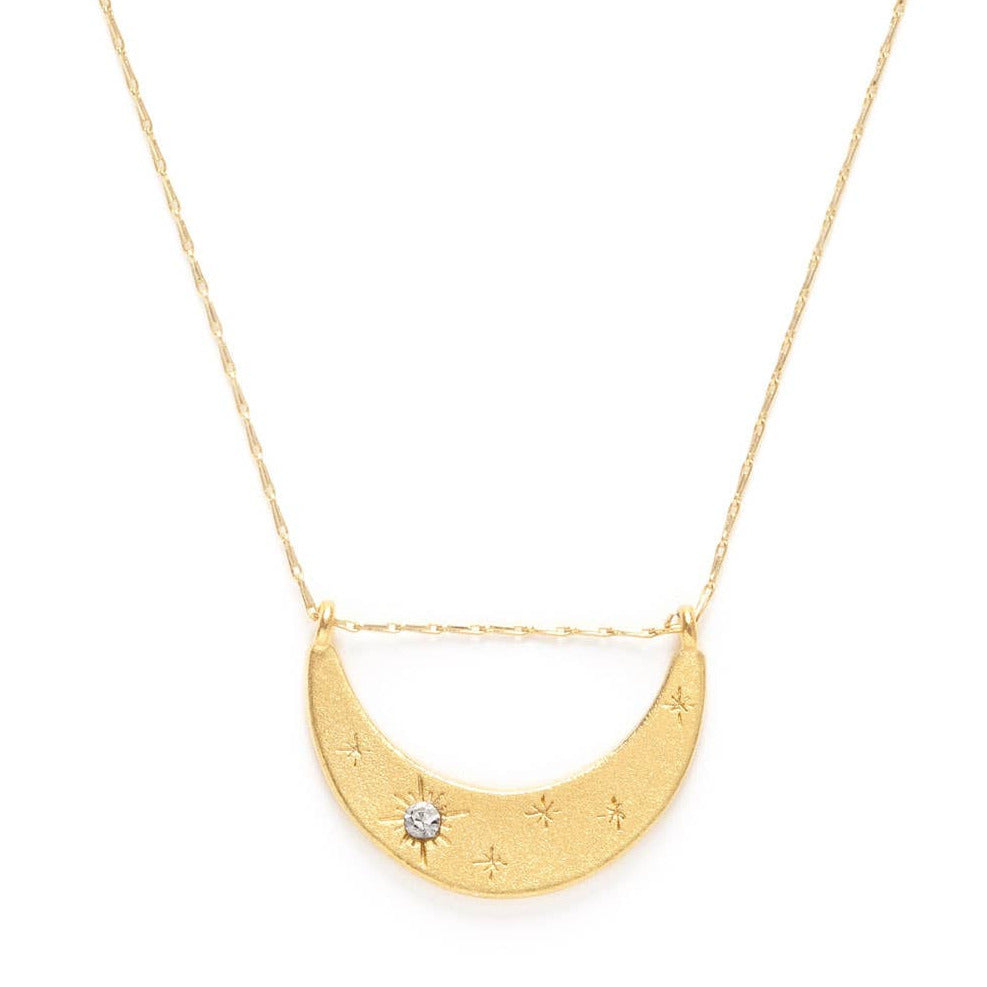 close up of a gold crescent moon necklace featuring a crystal. Brand: Amano Studio