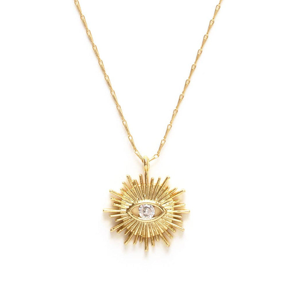 close up view of a gold necklace featuring an eye with a sun burst and crystal in the center of the eye. Brand: Amano Studio