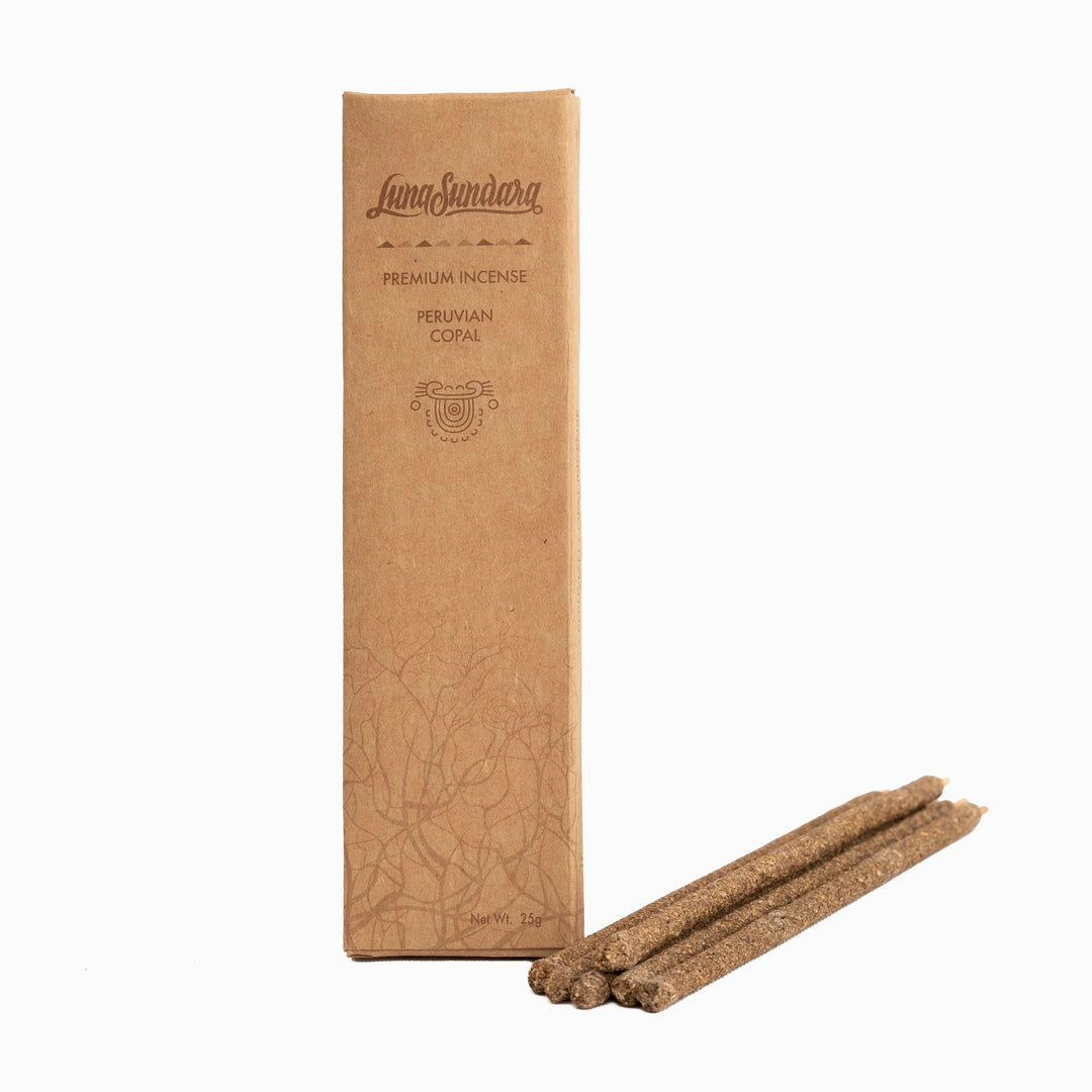 Six grey copal hand rolled incense sticks next to branded packaging. Brand: Luna Sundara