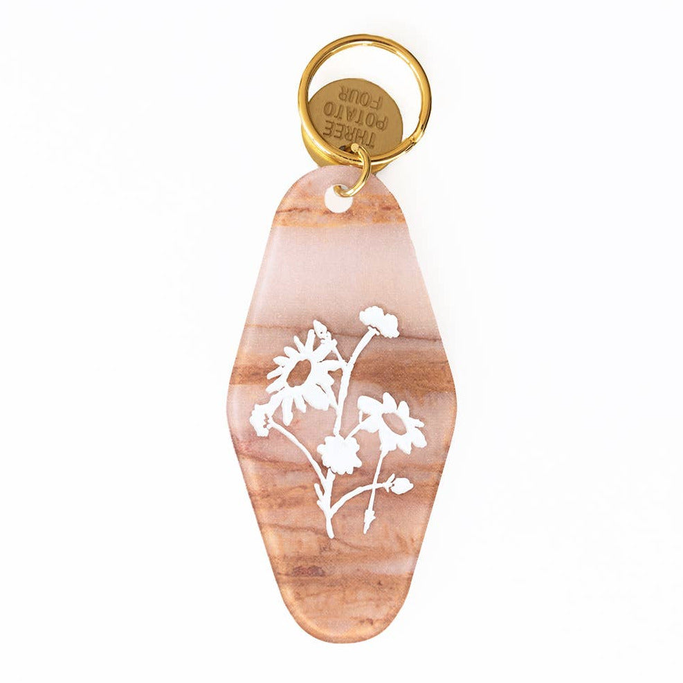 Marbled coral hotel keychain with an illustration of flowers in white with a gold ring