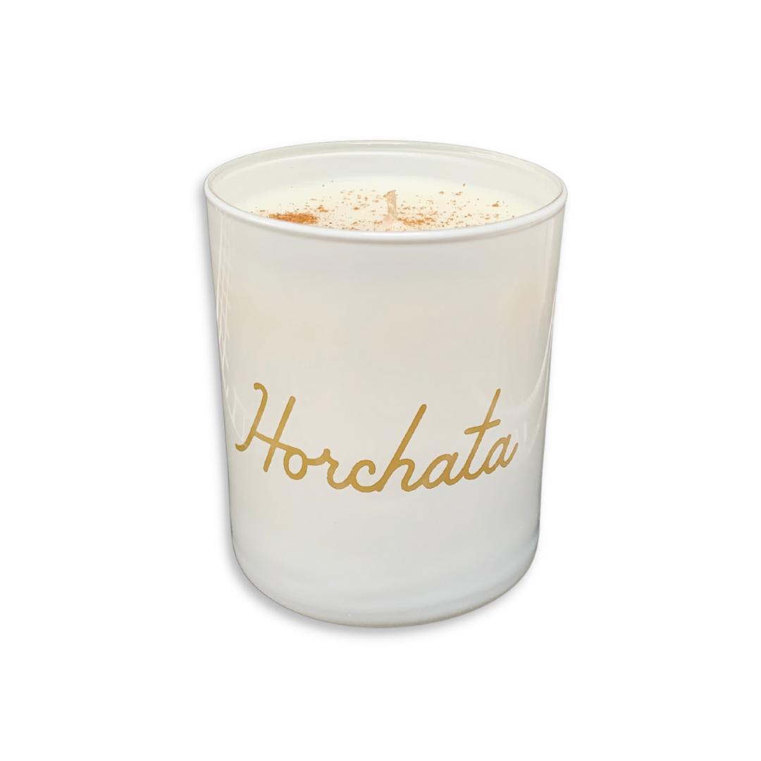 white candle with the word Horchata in gold cursive lettering. Brand: Sin-min