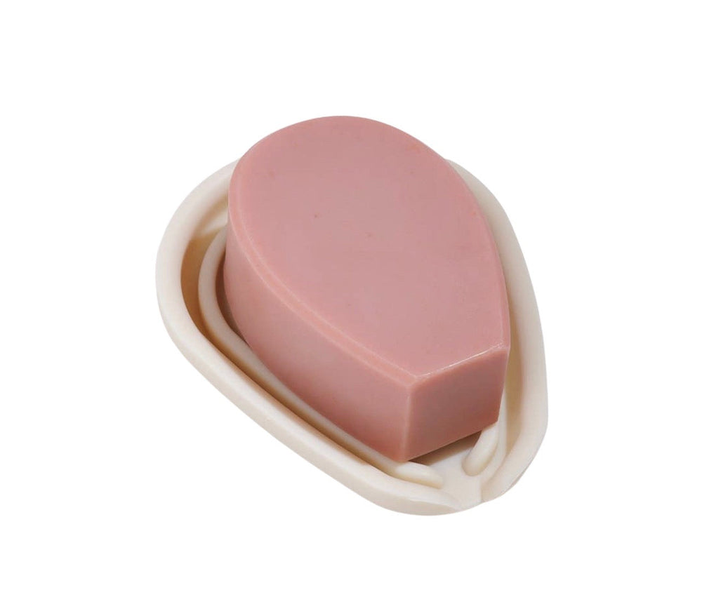 Pink bar of soap on top of a beige soap tray. Brand: Nopalera