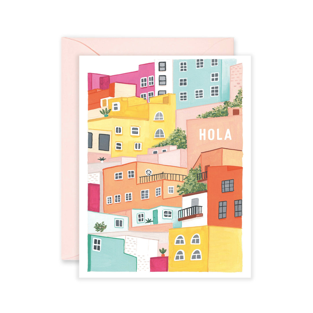 white card with an illustration of bright multi-colored homes and the phrase Hola in white lettering