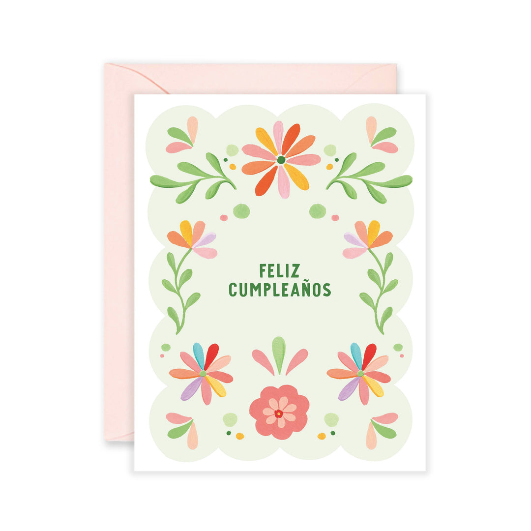 white and green card with a multi-colored floral design and the phrase Feliz Cumpleanos in the center in green lettering