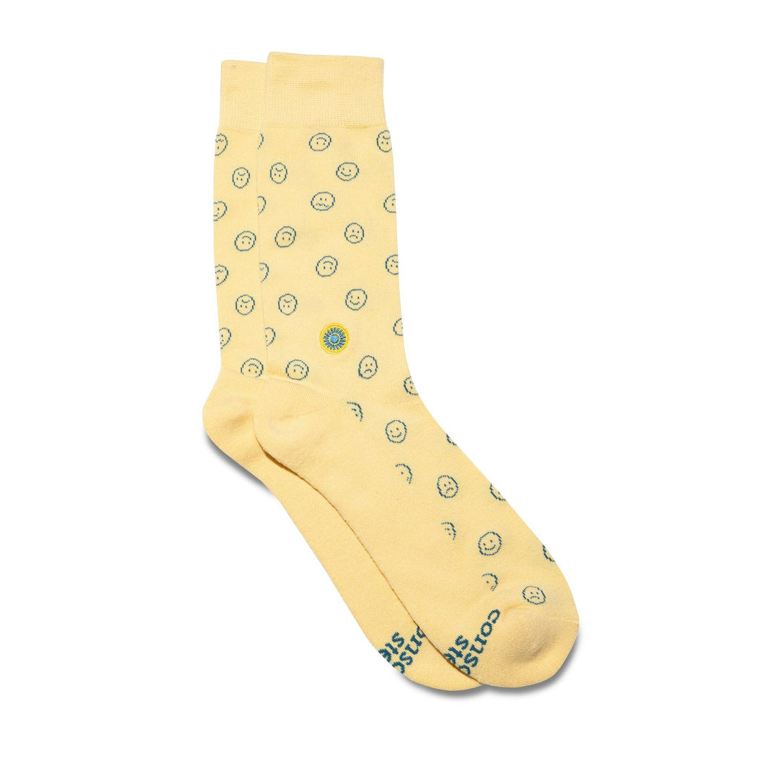 A pair of yellow socks with blue smiley faces